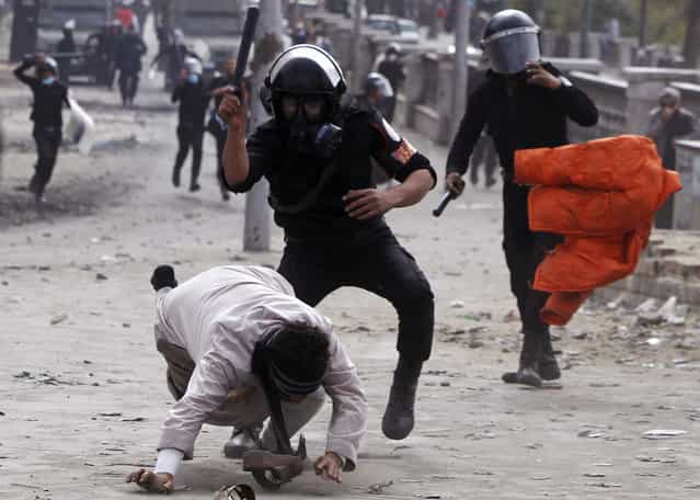 Riot policemen beat a protester opposing Egyptian President Mohamed Morsi, during clashes along Qasr Al Nil bridge, which leads to Tahrir Square in Cairo, on January 28, 2013. Monday was the fifth day of violence in Egypt that has killed 50 people and prompted the Islamist president to declare a state of emergency in an attempt to end a wave of unrest sweeping the Arab world's biggest nation. (Photo by Amr Abdallah Dalsh/Reuters/The Atlantic)