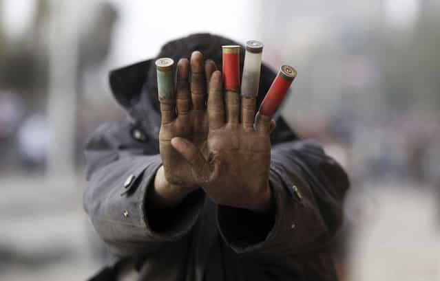A protester against President Mohamed Mursi shows expended shotgun cartridges that he said were fired by riot police during clashes along Qasr Al Nil bridge, which leads to Tahrir Square in Cairo, on January 27, 2013. (Photo by Amr Abdallah Dalsh/Reuters/The Atlantic)