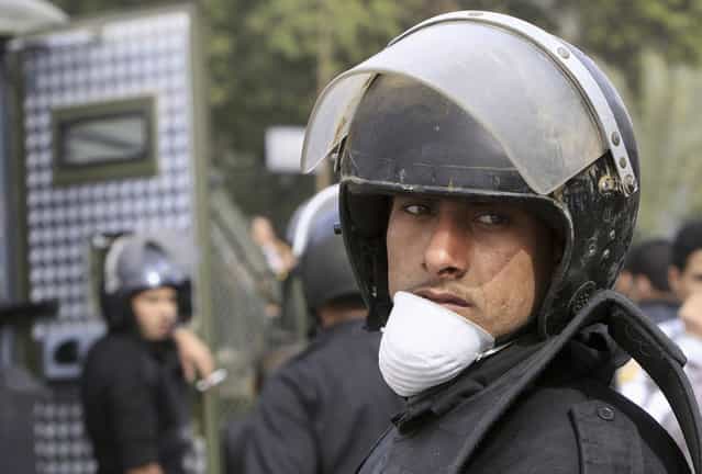 A riot police officer looks on during clashes between protesters opposing Egyptian President Mohamed Morsi, and riot police with other Egyptians fighting alongside them, along Qasr Al Nil bridge, in Cairo, on January 27, 2013. (Photo by Mohamed Abd El Ghany/Reuters/The Atlantic)