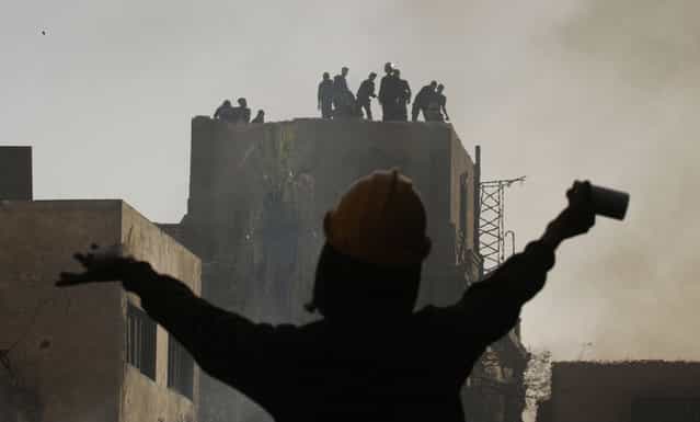 An Egyptian protester gestures towards riot police during a demonstration in Cairo's Tahrir Square on January 26, 2013. (Photo by Mohammed Abed/AFP Photo/The Atlantic)