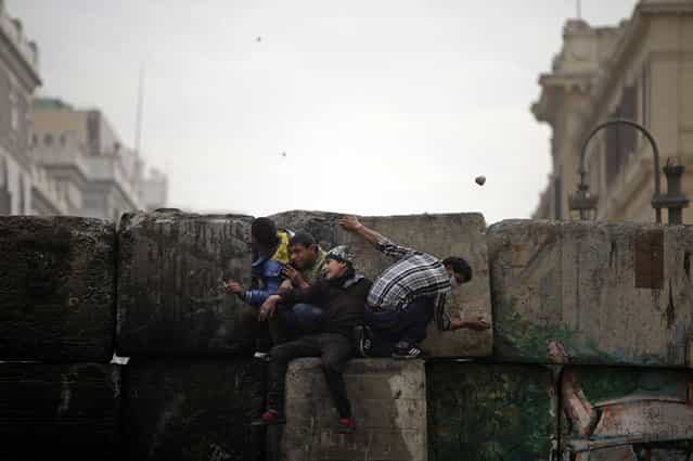 Skirmishes break out between protesters and security forces, unseen, near Tahrir Square, on January 25, 2013. (Photo by Khalil Hamra/AP Photo/The Atlantic)