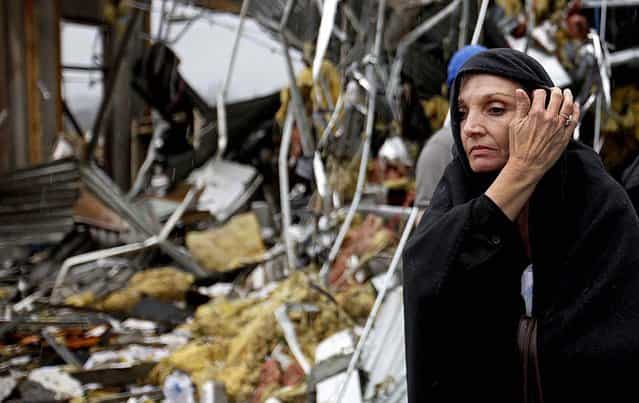 Pam Parker sifts through debris while looking for any personal belongings in the area where she was sitting at her desk when a tornado struck the Daiki plant, a metal fabrication company where she works in accounts payable in Adairsville. (Photo by David Goldman/Associated Press)