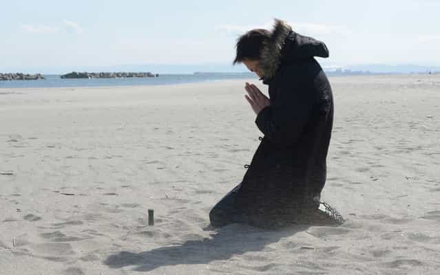 Nobuhisa Iwai prays for his friend killed by the tsunami at Arahama district in Sendai. Japan today marked the second anniversary of the ferocious tsunami that claimed nearly 19,000 lives and sparked the worst nuclear accident in a generation. (Photo by Toru Yamanaka/AFP Photo)
