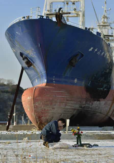 A man prays to mourn victims of the March 11, 2011, earthquake and tsunami in front of a ship brought ashore by the disaster in Kesennuma, Miyagi Prefecture, Japan. (Photo by Kyodo via Reuters)