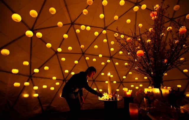 A woman lights candles to pay tribute to the victims of the March 11, 2010 earthquake and tsunami at a make-shift altar in a park in Tokyo. (Photo by Junji Kurokawa/Associated Press)