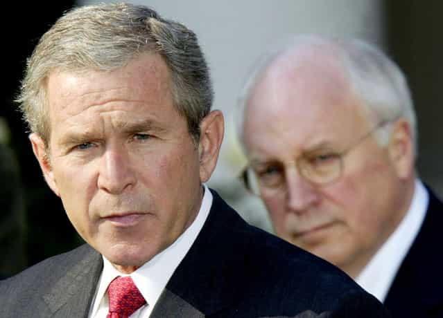U.S. President George W. Bush, watched by Vice President Dick Cheney, speaks before signing a $355 billion military spending bill in the Rose Garden of the White House October 23, 2002. The bill gave the Pentagon a nearly $40 billion boost as it prepared for possible war with Iraq, the White House said. (Photo by Kevin Lamarque/Reuters/The Atlantic)
