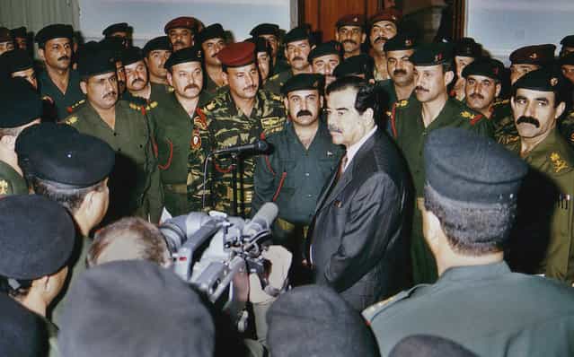 Iraqi President Saddam Hussein, center, talks with elite Republican Guard officers in Baghdad, on March 1, 2003. Iraq began destroying its Al Samoud 2 missiles Saturday as ordered by the United Nations and agreed with weapons inspectors on a timetable to dismantle the entire missile program, U.N. and Iraqi officials said. (Photo by AP Photo/INA/The Atlantic)