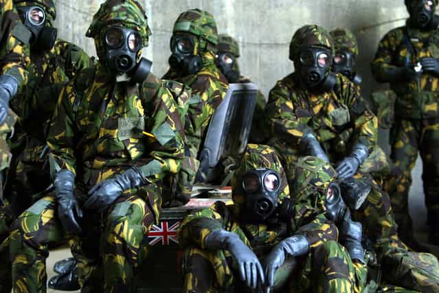 British Royal Air Force personnel wait in a bunker wearing full Nuclear Biological and Chemical suits after a warning of a Scud missile attack on their base in Kuwait March 20, 2003. (Photo by Russell Boyce/Reuters/The Atlantic)