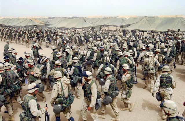 US Marines from the 2nd battalion/8 MAR, prepare themselves after receiving orders to cross the Iraqi border at Camp Shoup, northern Kuwait, on March 20, 2003. (Photo by Eric Feferberg/AFP Photo/The Atlantic)