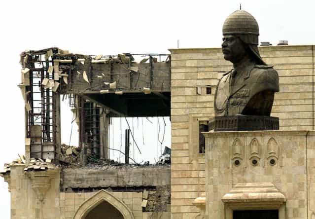 A statue of Iraqi President Saddam Hussein, at his palace, damaged during a U.S. led air strike in Baghdad, on March 23, 2003. (Photo by Faleh Kheiber/Reuters/The Atlantic)