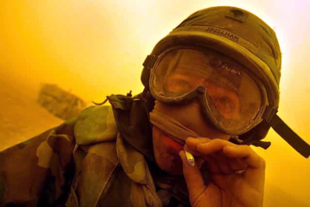 A U.S. Army combat engineer enjoys a cigarette as he relaxes between the cities of Najaf and Karbala as another sandstorm turned the daylight orange, on March 26, 2003. (Photo by Kai Pfaffenbach/Reuters/The Atlantic)