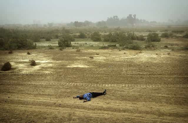A body of Iraqi man lies by the road side north of Al Nassiriyah, on March 25, 2003. More than 30 men of military age were killed on the key northern highway by an apparent U.S. air strike on the vehicles carrying the Iraqis. (Photo by Damir Sagolj/Reuters/The Atlantic)