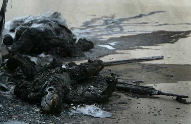 The charred remains of dead Iraqi soldiers lay outside a bus hit by a U.S. tank shell on a highway between Baghdad's international airport and the city center, on April 7, 2003. (Photo by Kai Pfaffenbach/Reuters/The Atlantic)
