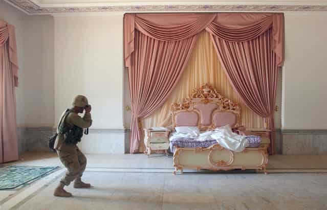US Army Sergeant Craig Zentkovich from Connecticut belonging to the 1st Brigade Combat Team photographs a pink bedroom at Saddam Hussein's presidential palace, on April 13, 2003. (Photo by Romeo Gacad/AFP Photo/The Atlantic)