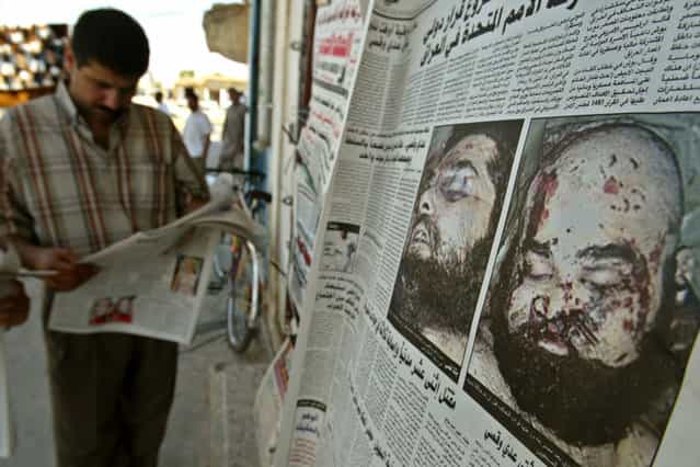 A man reads an Iraqi newspaper in the northern town of Tikrit after morgue photos of Saddam Hussein's sons Uday and Qusay were published for the first time, on July 26, 2003. Hoping to convince Iraqis that the two men were dead, the U.S. military released photos of the pair on Thursday and allowed a small group of media to view the bodies. (Photo by Faleh Kheiber/Reuters/The Atlantic)