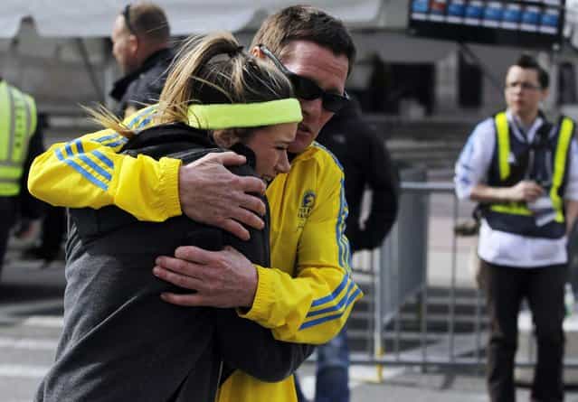 A woman is comforted by a man near a triage tent set up for the Boston Marathon after explosions went off at the 117th Boston Marathon in Boston, Massachusetts April 15, 2013. (Photo by Jessica Rinaldi/Reuters)