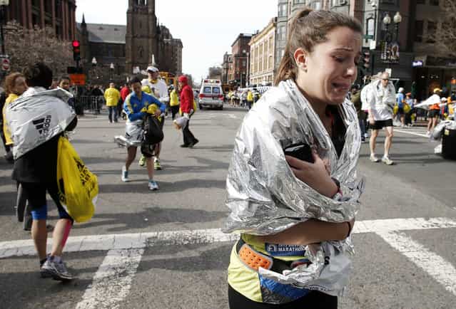 An unidentified Boston Marathon runner leaves the course crying near Copley Square following an explosion in Boston Monday, April 15, 2013. (Photo by Winslow Townson/AP Photo)