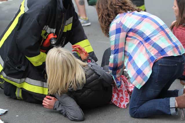An injured woman is attended to at the scene of an explosion at the Boston Marathon in Boston, Massachusetts, April 15, 2013. (Photo by Kenshin Okubo/Reuters/Daily Free Press/Boston University)