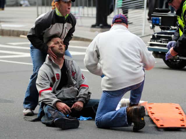 In this photo provided by The Daily Free Press and Kenshin Okubo, people assist an injured after an explosion at the 2013 Boston Marathon in Boston, Monday, April 15, 2013. (Photo by Kenshin Okubo/AP Photo/The Daily Free Press)