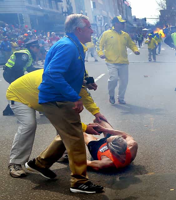 People react to a second explosion at the 2013 Boston Marathon in Boston, Monday, April 15, 2013. (Photo by John Tlumacki/AP Photo/The Boston Globe)