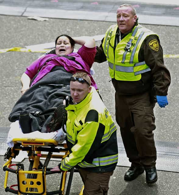 Medical workers aid an injured woman at the finish line of the 2013 Boston Marathon following two explosions there, Monday, April 15, 2013 in Boston. (Photo by Charles Krupa/AP Photo)