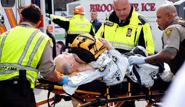 A man is loaded into an ambulance after he was injured by one of two bombs exploded during the 117th Boston Marathon near Copley Square on April 15, 2013 in Boston, Massachusetts. (Photo by Jim Rogash)
