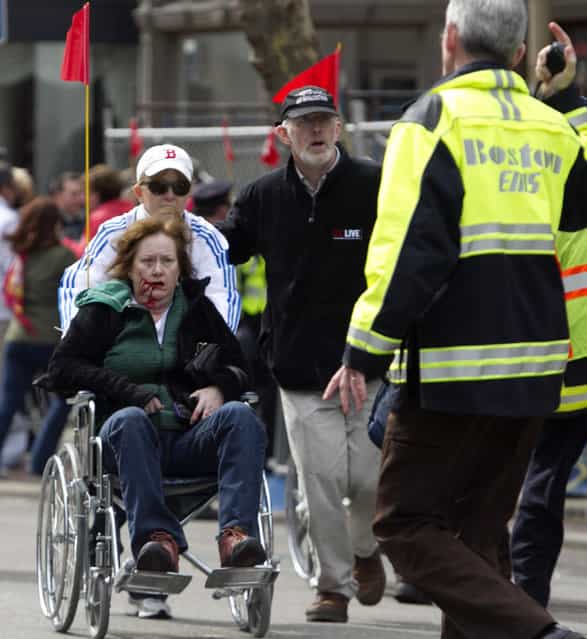First responders transport an injured woman in a wheelchair where two explosions occurred along the final stretch of the Boston Marathon on Boylston Street in Boston, Massachusetts, U.S., on Monday, April 15, 2013. (Photo by Kelvin Ma/Bloomberg)