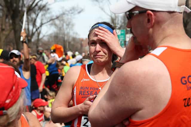 A runner reacts near Kenmore Square after two bombs exploded during the 117th Boston Marathon on April 15, 2013 in Boston, Massachusetts. (Photo by Alex Trautwig)