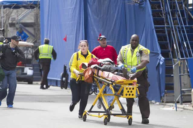 First responders transport the wounded where two explosions occurred along the final stretch of the Boston Marathon on Boylston Street in Boston, Massachusetts, U.S., on Monday, April 15, 2013. (Photo by Kelvin Ma/Bloomberg)
