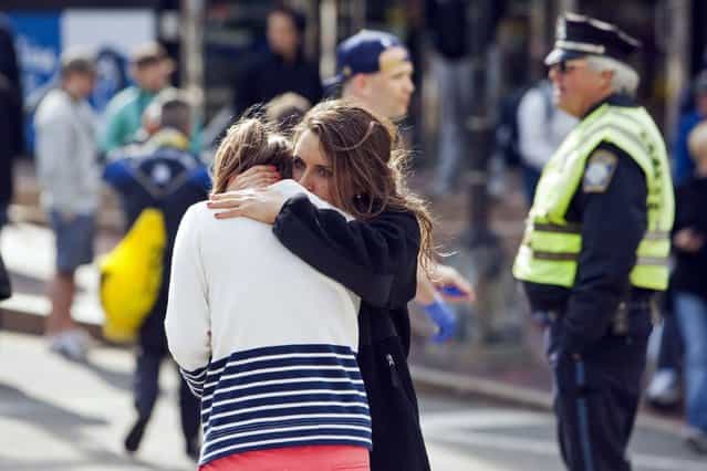 A woman comforts another, who appears to have suffered an injury to her hand, after explosions interrupted the 117th Boston Marathon in Boston, Massachusetts April 15, 2013. (Photo by Dominick Reuter/Reuters)
