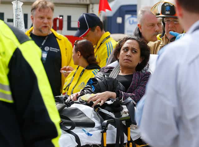A woman is loaded into an ambulance after he was injured by one of two bombs exploded during the 117th Boston Marathon near Copley Square on April 15, 2013 in Boston, Massachusetts. (Photo by Jim Rogash)
