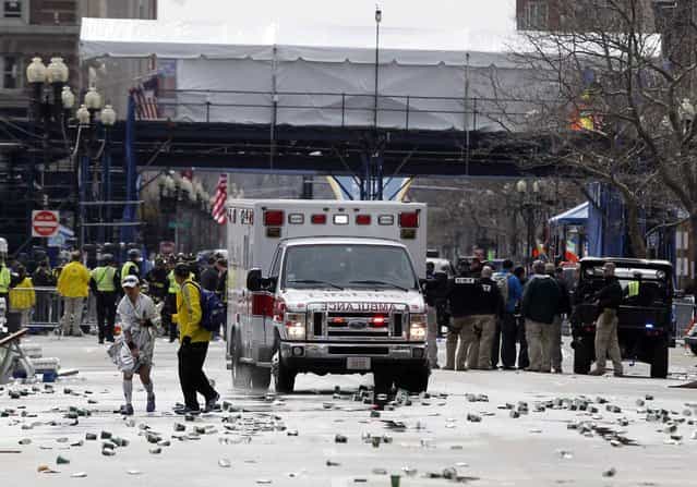 A runner is escorted from the scene after explosions went off at the 117th Boston Marathon in Boston, Massachusetts April 15, 2013. (Photo by Jessica Rinaldi/Reuters)
