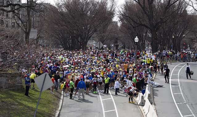 Runners who had not yet finished the race are stopped before the Massachusetts Avenue overpass on Commonwealth Avenue following the explosions. (Photo by Yoon S. Byun/The Boston Globe)