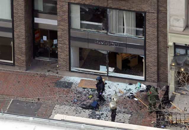 A man in a bomb-disposal suit investigates the site of an explosion which went off on Boylston Street during the 117th Boston Marathon in Boston, Massachusetts April 15, 2013. (Photo by Jessica Rinaldi/Reuters)