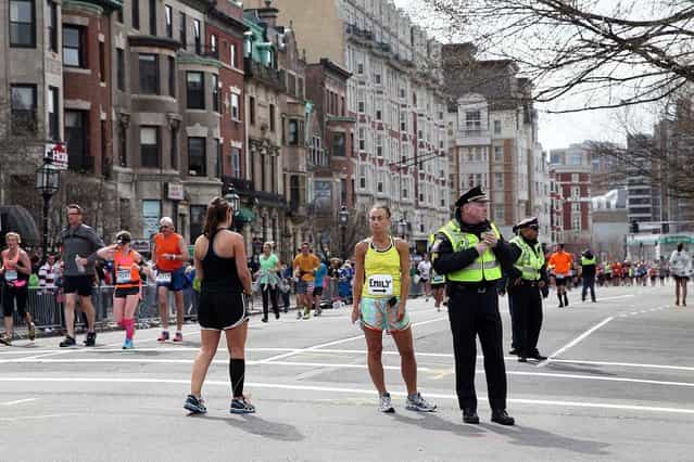 Police and runners stand near Kenmore Square after two bombs exploded during the 117th Boston Marathon on April 15, 2013 in Boston, Massachusetts. (Photo by Alex Trautwig)