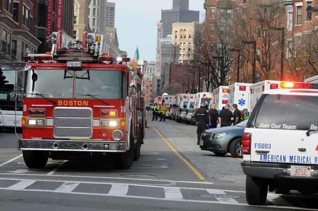 A long line of ambulances wait in a staging area after explosions rocked the finish area of the Boston Marathon on April 15, 2013 in Boston, Massachusetts. At least two people were killed and 22 wounded when two explosions struck near the finish line of the Boston Marathon, sparking scenes of panic, police said. The streets were littered with debris and blood and paramedics raced off with stretchers as police locked down the area, witness said. TV footage showed an explosion sending up a white plume of smoke along the sidelines of the race. (Photo by John Mottern/AFP Photo)