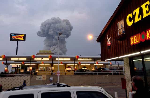 People at a Czech Stop look at a cloud of smoke rising from the explosion in West, Texas, April 17, 2013. (Photo by Andy Bartee via Dallas Morning News/MCT)