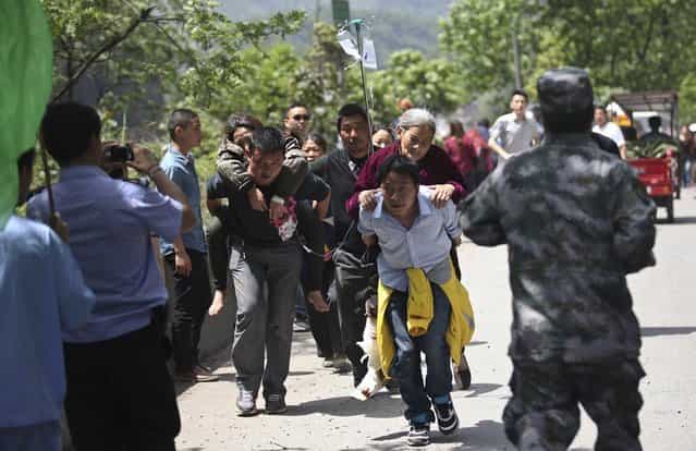 Men carry injured people to an ambulance at Longmen Village, Lushan county, Ya'an, Sichuan province, April 20, 2013. A strong 6.6 magnitude earthquake hit a remote, mostly rural and mountainous area of southwestern China's Sichuan province on Saturday, killing at least 102 people and injuring about 2,200 close to where a big quake killed almost 70,000 people in 2008. (Photo by Reuters/Stringer)