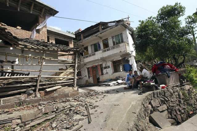 People rest outside damaged houses after a strong 6.6 magnitude earthquake hit, at Longmen village, Lushan county, Ya'an, Sichuan province April 20, 2013. (Photo by Reuters/Stringer)