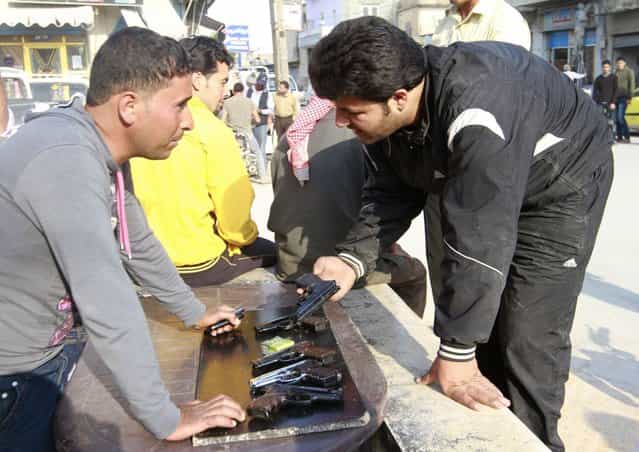 People sell hand guns on a street in the Syrian town of Tel Abyad April 23, 2013. Picture taken April 23, 2013. (Photo by Hamid Khatib/Reuters)