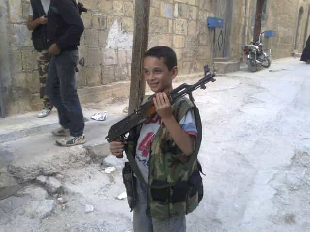 A boy poses with a rifle in Kafr Takharim, on the outskirts of Idlib July 17, 2012. Picture taken July 17, 2012. (Photo by Reuters/Shaam News Network)