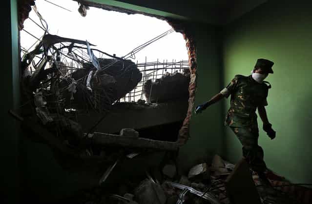 A soldier walks through the rubble on Wednesday. (Photo by Kevin Frayer/Associated Press)