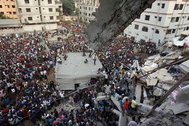 Rescue workers try to rescue trapped garment workers in the Rana Plaza building which collapsed, in Savar, 30 km (19 miles) outside Dhaka April 24, 2013. A block housing garment factories and shops collapsed in Bangladesh on Wednesday, killing nearly 100 people and injuring more than a thousand, officials said. (Photo by Andrew Biraj/Reuters)