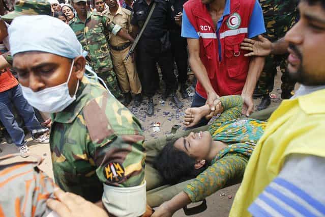 Rescue workers carry a survivor, who was trapped inside the rubble of the collapsed Rana Plaza building, in Savar, 30 km (19 miles) outside Dhaka April 25, 2013. The death toll from a building collapse in Bangladesh has risen to 160 and could climb higher, police said on Thursday, with people trapped under the rubble of a complex that housed garment factories supplying retailers in Europe and North America. (Photo by Andrew Biraj/Reuters)