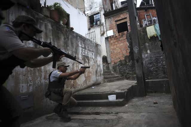 Police react while on patrol in the Nordeste de Amaralina slum complex in Salvador, Bahia State, March 28, 2013. One of Brazil's main tourist destinations and a 2014 World Cup host city, Salvador suffers from an unprecedented wave of violence with an increase of over 250% in the murder rate, according to the Brazilian Center for Latin American Studies (CEBELA). (Photo by Lunae Parracho/Reuters)