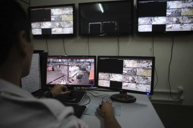 A police officer watches live security cameras aimed at different points of the city where violence is common, at a command center in Salvador, Bahia State, March 28, 2013. (Photo by Lunae Parracho/Reuters)