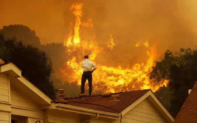 A man watches the approaching flames as the Springs fire continues to grow near Camarillo, California, on May 3, 2013. The wildfire has spread to more than 18,000 acres on day two and is 20 percent contained. (Photo by David McNew/Getty Images)