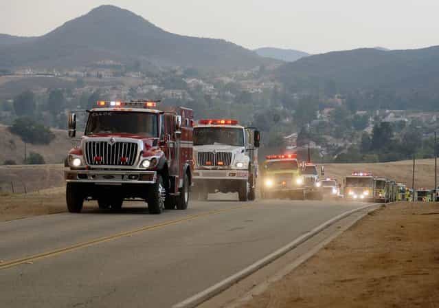 Fire trucks arrive to protect homes on Potrero Road as wildfire charges back up from Sycamore Canyon inside Pt. Mugu State Park on May 3, 2013 in Newbury Park, California. Hundreds of firefighters continue to battle wind and dry conditions with over 10,000 acres burned. (Photo by Kevork Djansezian/Getty Images)