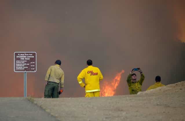 Firefighters look on as wildfire charges back up from Sycamore Canyon inside Pt. Mugu State Park after after changing winds on May 3, 2013 in Newbury Park, California. (Photo by Kevork Djansezian/Getty Images)