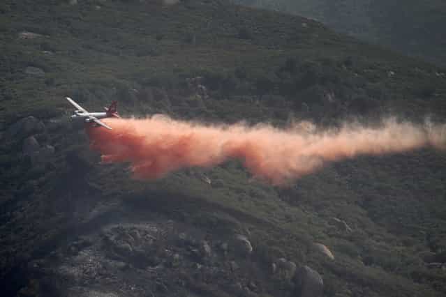 A firefighting air tanker plane drops fire retardant in Hidden Valley at the Springs fire on May 4, 2013 near Camarillo, California. Improving weather conditions are helping firefighters get the upper hand on the wildfire which has grown to 28,000 acres and is now 56 percent contained. (Photo by David McNew/AFP Photo)